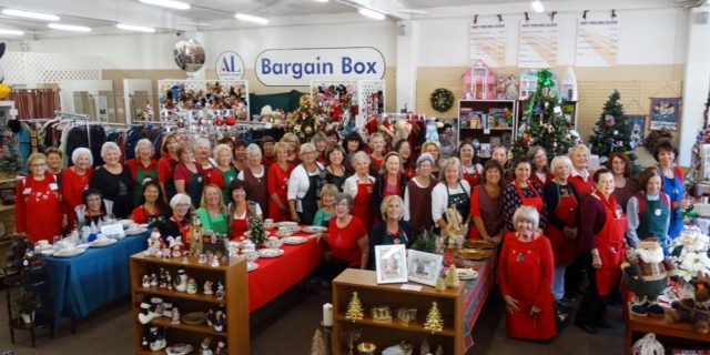 ALA’s Holiday Boutique Photo a large group of women standing in a thrift store with a sign that reads Bargain Box