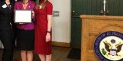 Judy Chu three women stand off to the side of a podium with a congressional seal on it