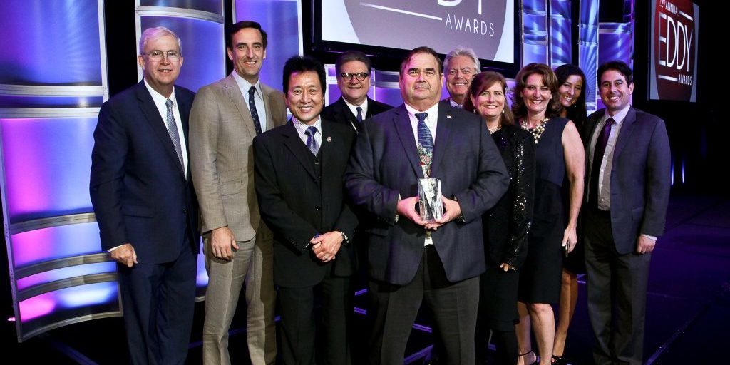 a group of people at the Eddy Awards holding a statue