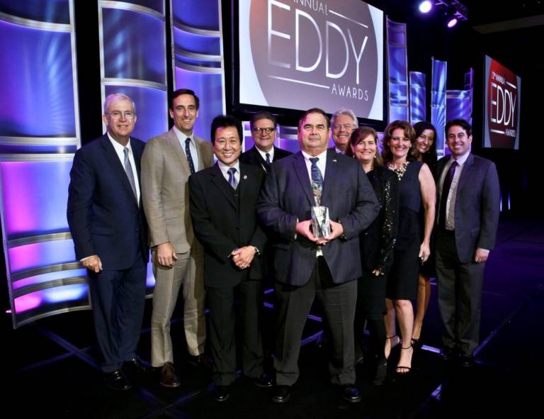 a group of people at the Eddy Awards holding a statue