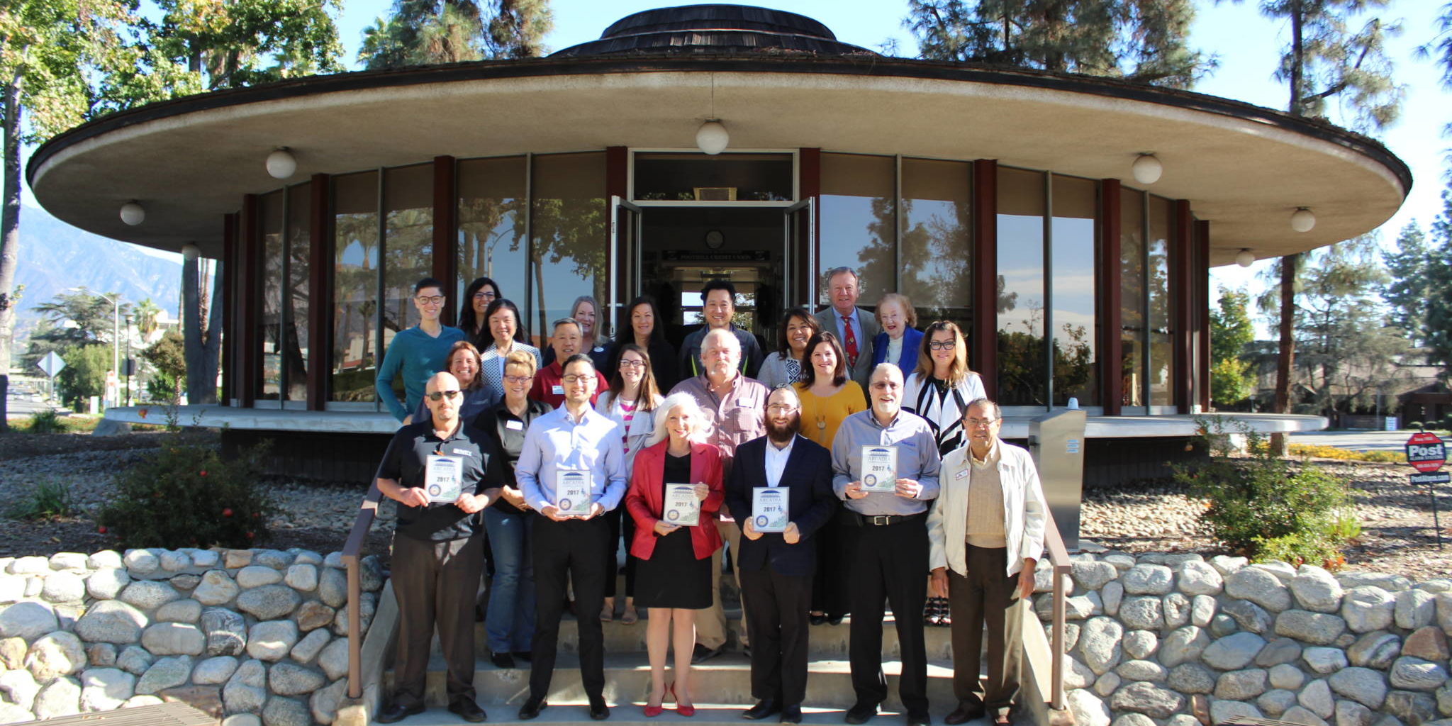 a group of people standing on the back steps of the Arcadia Chamber building
