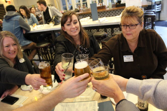 a group of people cheering with glasses of soda
