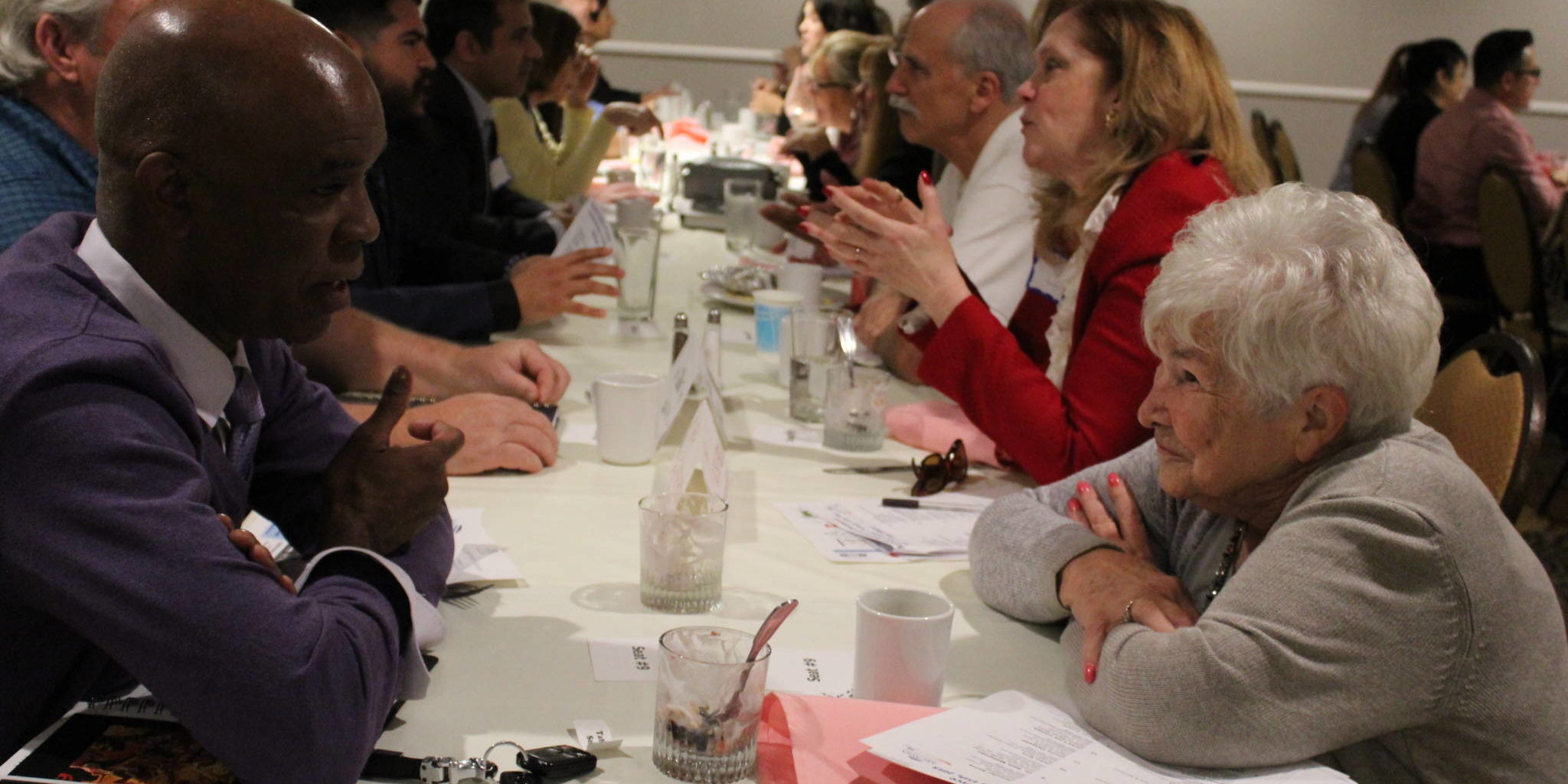 a line of people seated across from each other talking