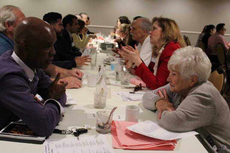 a line of people seated across from each other talking