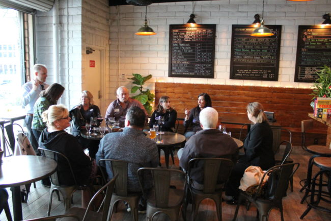 IMG_1491 a group of people sitting in a the round in a wine bar