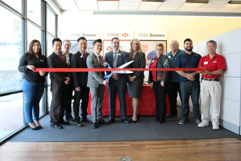 a group of people in bank getting ready for a ribbon cutting