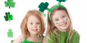 two girls dressed in green wearing st patricks day stickers on their faces