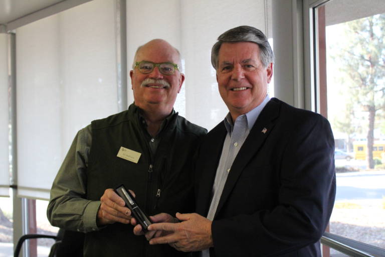 two men holding a pen