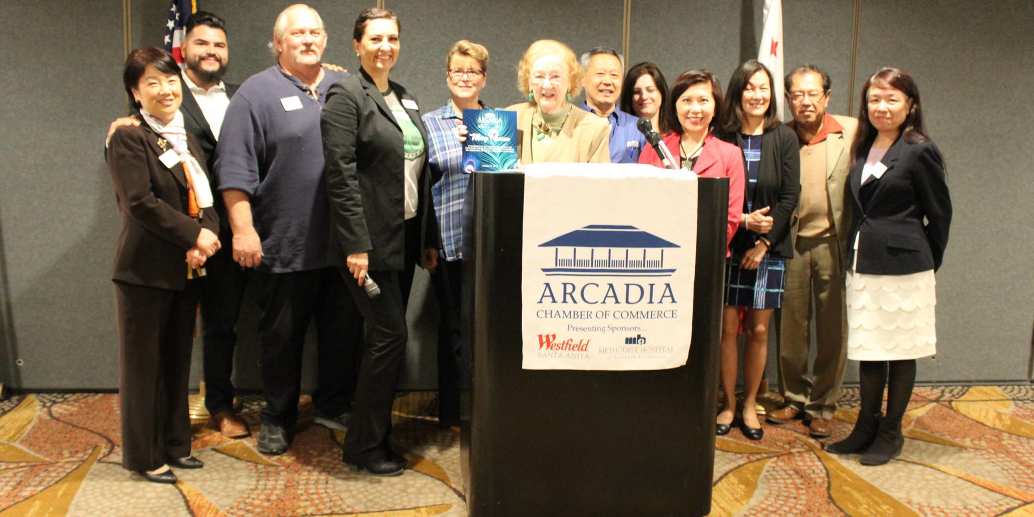 IMG_2591 a group of people standing in front of a podium