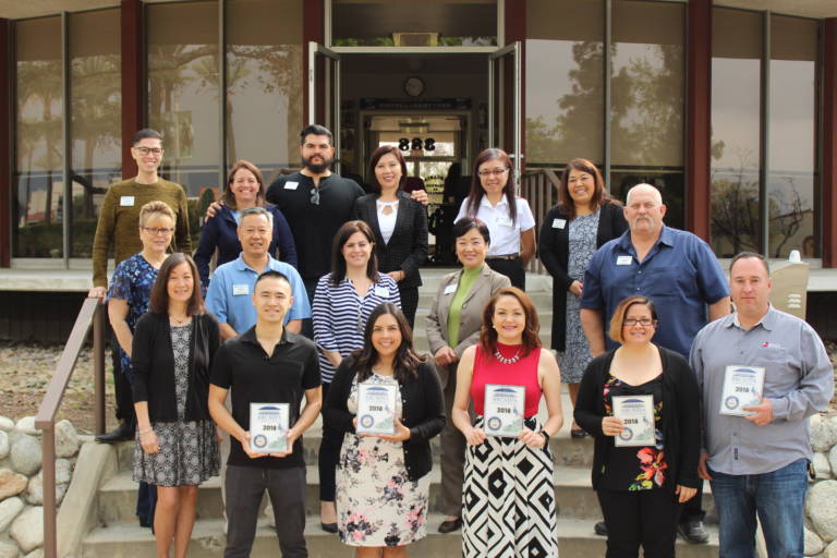 a group of people standing on the back steps of the arcadia chamber building