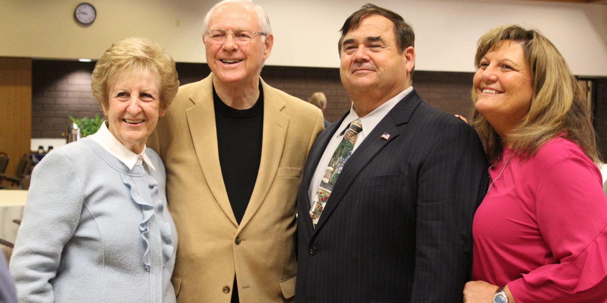 two nicely dressed women standing beside two men in suit jackers