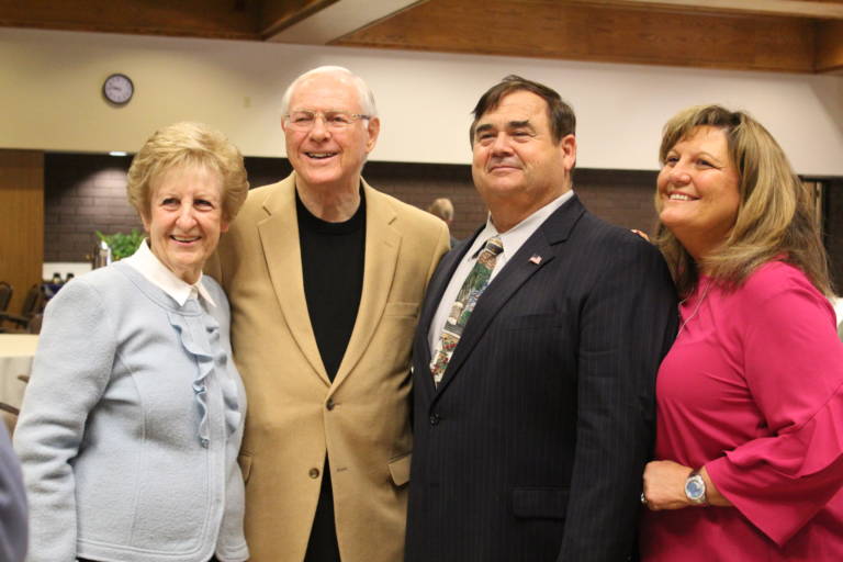 two nicely dressed women standing beside two men in suit jackers