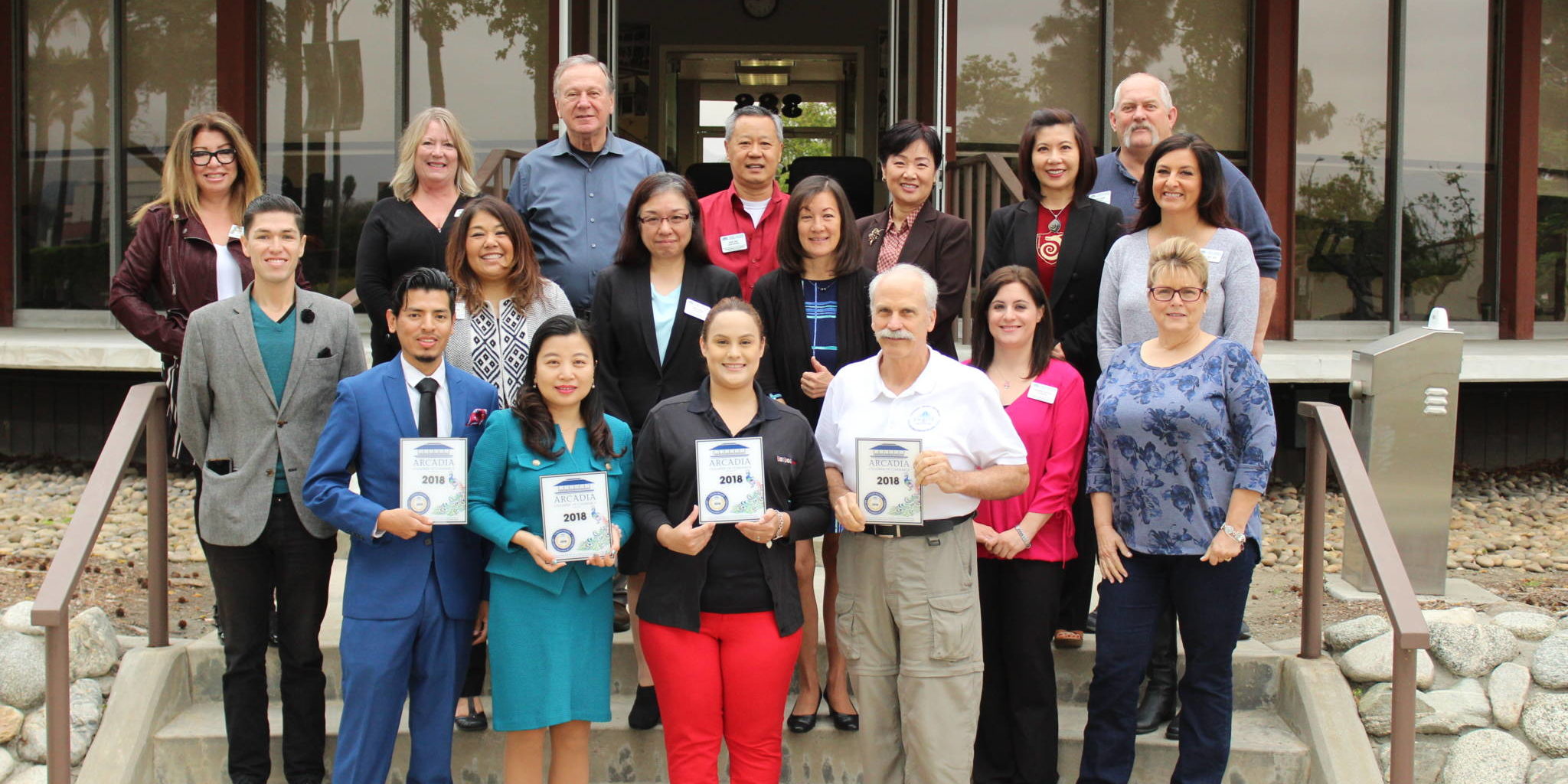 a group of people standing on the back steps of the Arcadia Chamber building