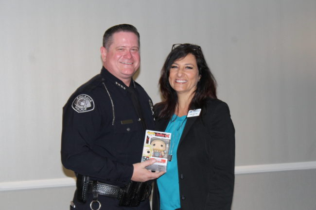 IMG_7899 a man in uniform holding a pop figure and standing next to a woman in a blue shirt and black jacket