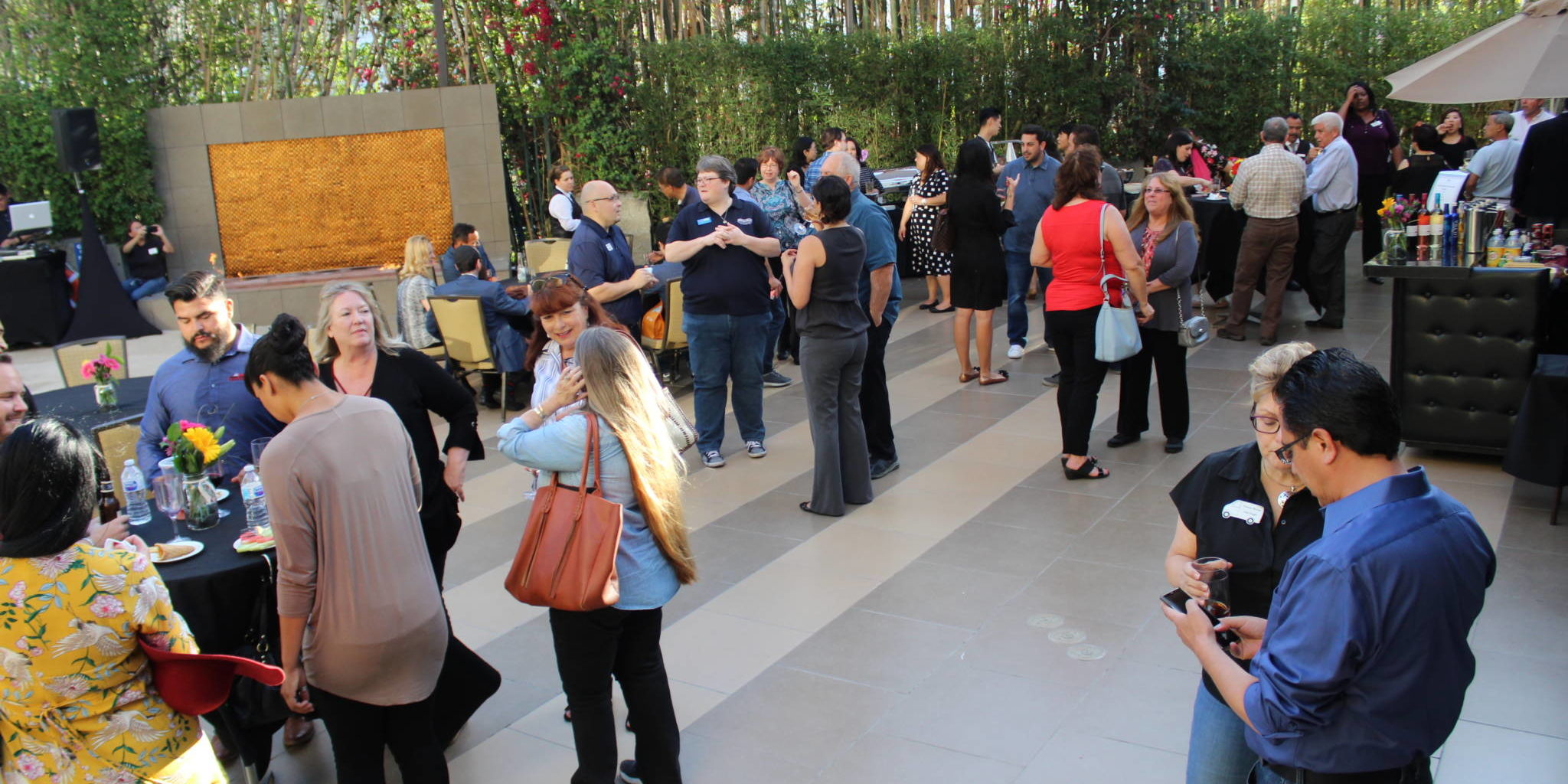 a group of people on an outdoor patio beside a water fountain