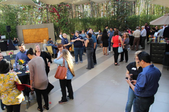 a group of people on an outdoor patio beside a water fountain