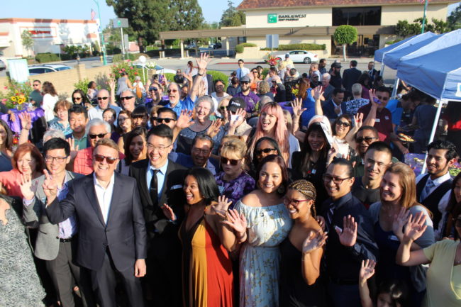 a group of people at a ribbon cutting seen from above