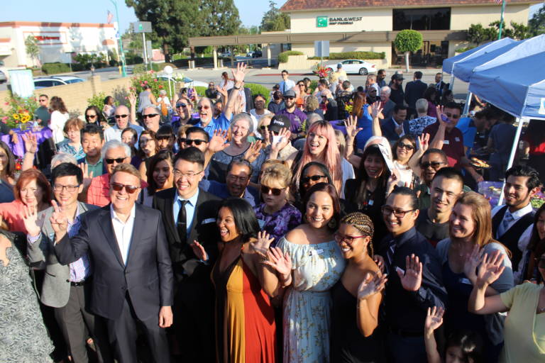 a group of people at a ribbon cutting seen from above