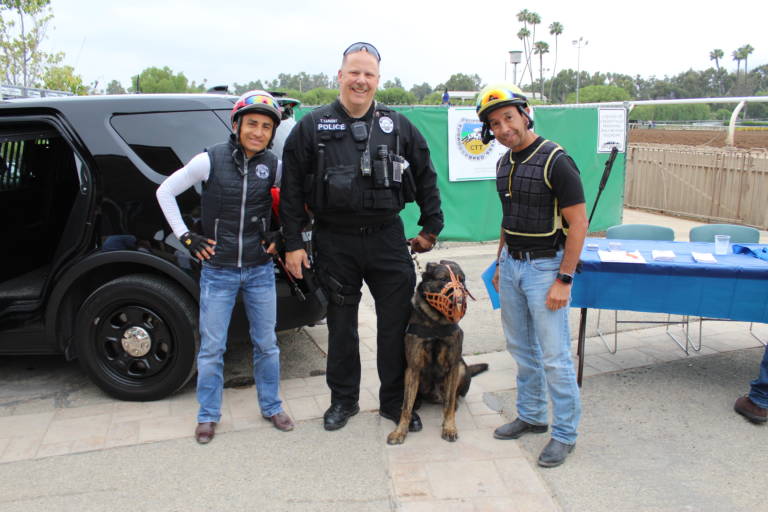 IMG_3435 a man in a police uniform with his police dog standing between two jockeys