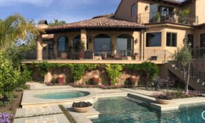 home with a pool in Spanish style by Romani Construction 