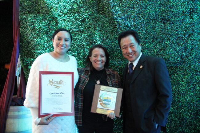 Christine Zito showcasing awards won at ACE Awards dinner, with Mayor Sho Tay