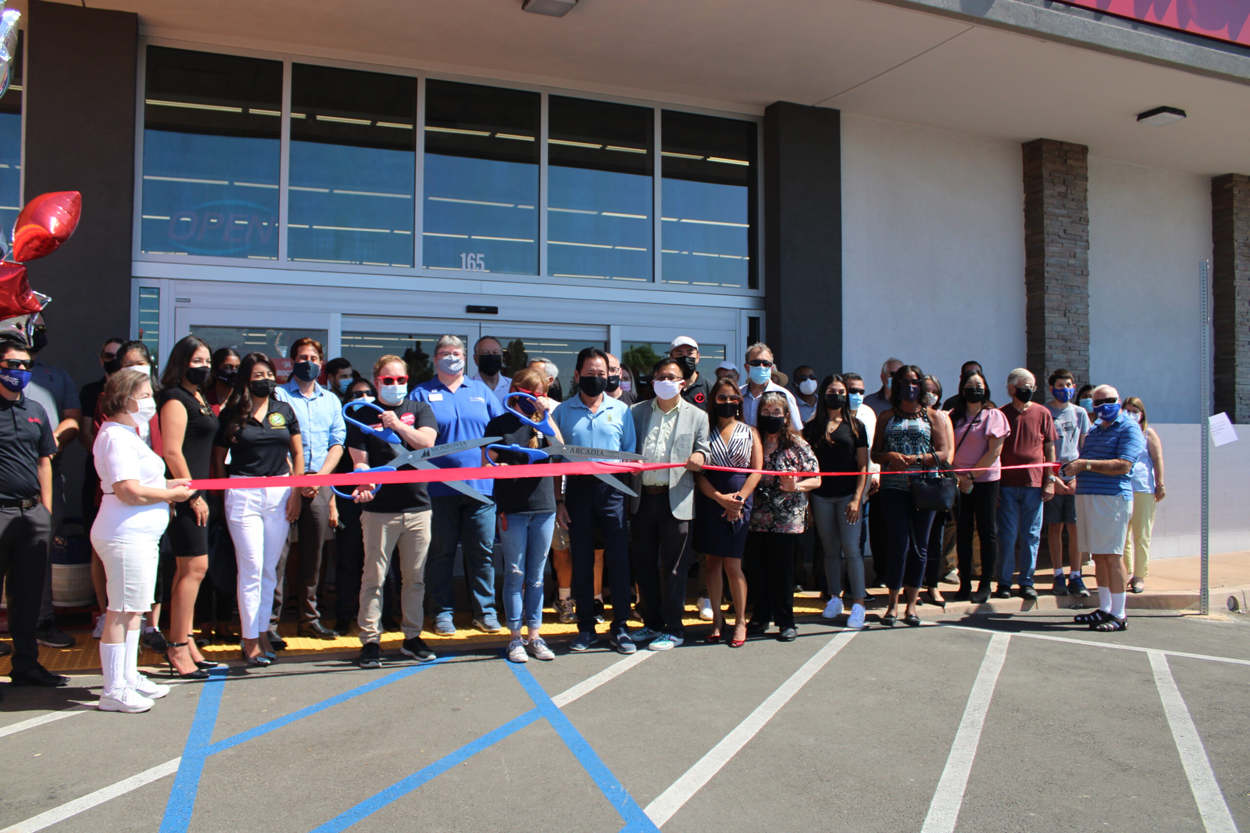 Grocery Outlet Foothill Ribbon Cutting ceremony showing a line of people with a red ribbon