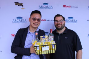 two men holding a gift basket full of liquor items