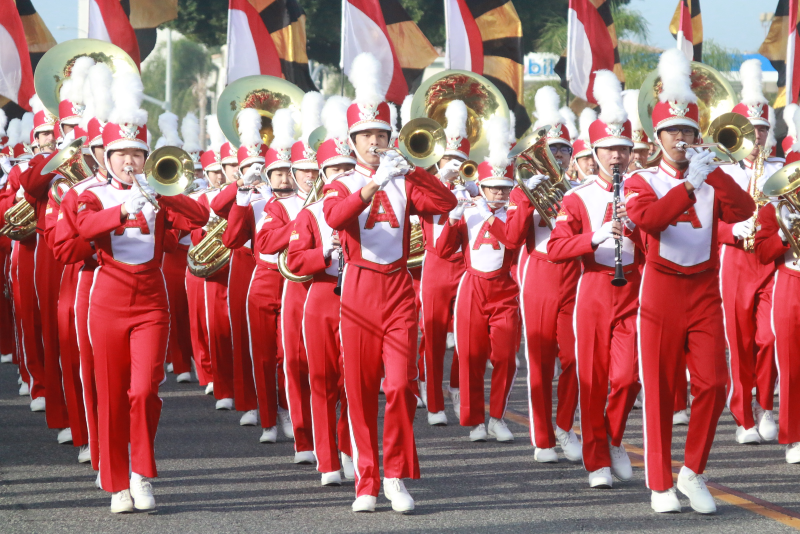 Arcadia Band dressed in red and white uniforms marching with their instruments