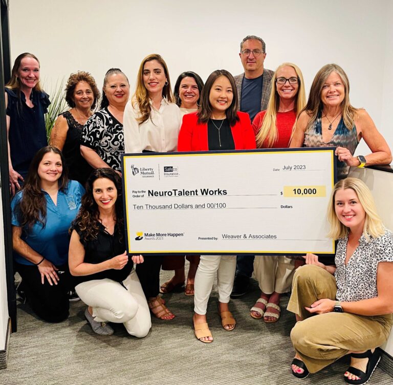a group of people holding an oversized check from Weaver and Associates