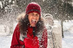 a woman in the snow getting a snowball thrown at her 