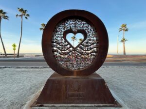 a sculpture on the beach in the shape of a circle with a heart in the center
