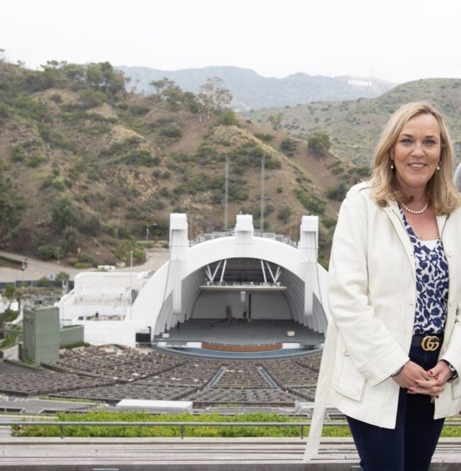 Supervisor Kathryn Barger stands above the Hollywood Bowl with the mountains and Hollywood Sign behind her