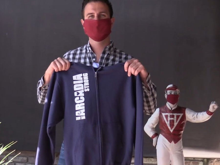 Tyler, General Manager of The Derby holding a Arcadia Strong sweatshirt.