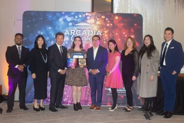 a woman in a leopard print dress standing in t he middle of a group of people holding a bunch of plaques