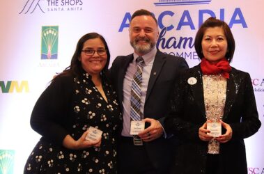 two women flanking a man and all are holding a paperweight with their names on them