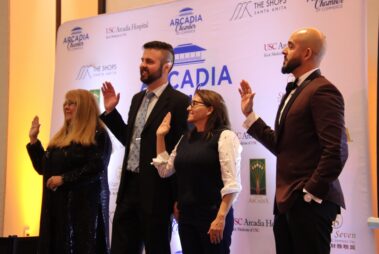 a group of four, two women and two men, holding up their right hands in a swearing in ceremony