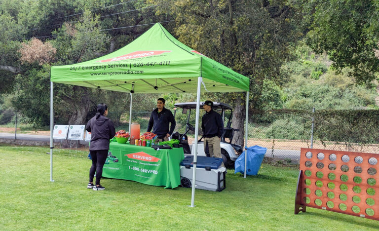 a green Servpro booth with a giant Connect Four set up beside it