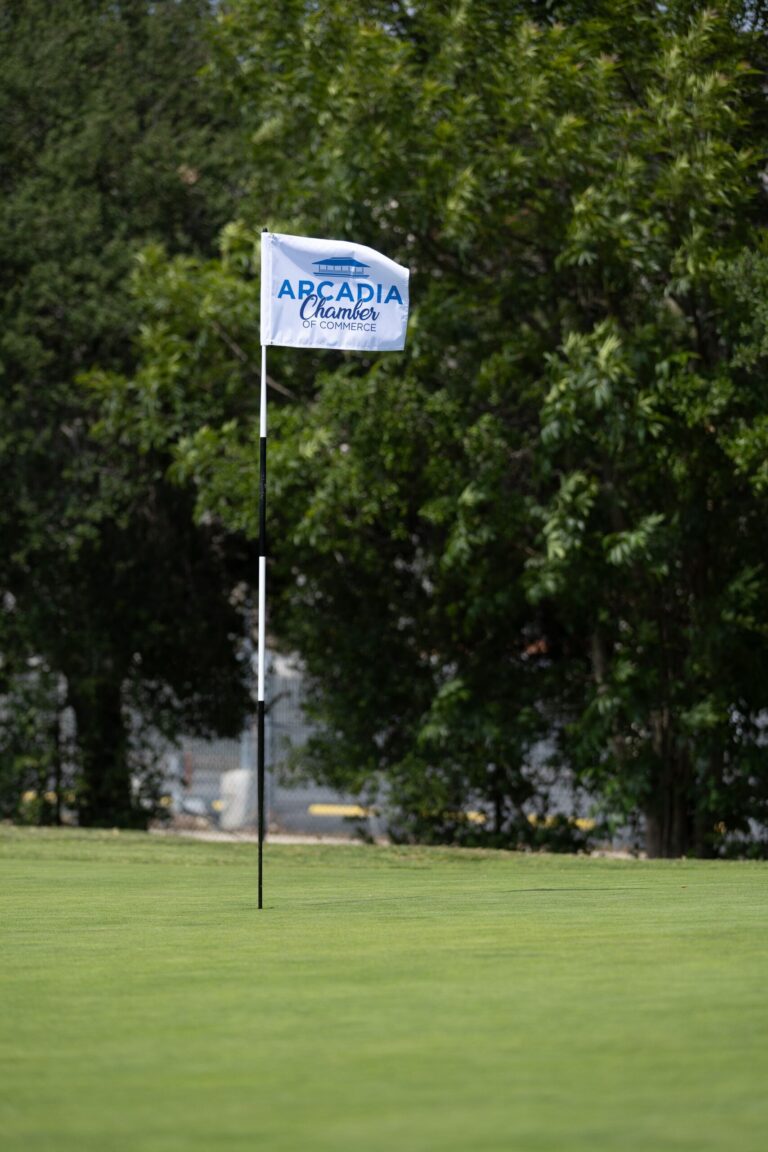 a golf flag with the Arcadia Chamber logo on it