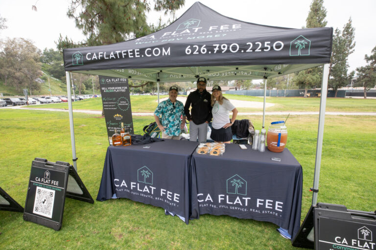 a booth with CA Flat Fee logos on it with three people standing beneath a tent