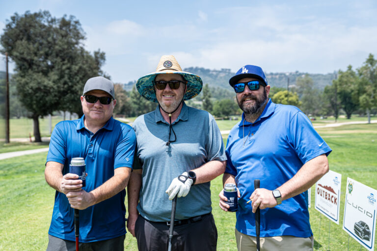 a group of three golfers in blue golf shirts