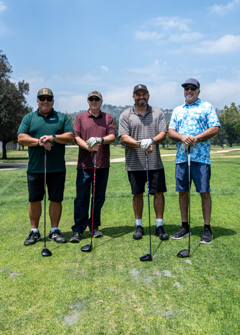 a group of four golfers posing with their clubs, from Pure Media Marketing