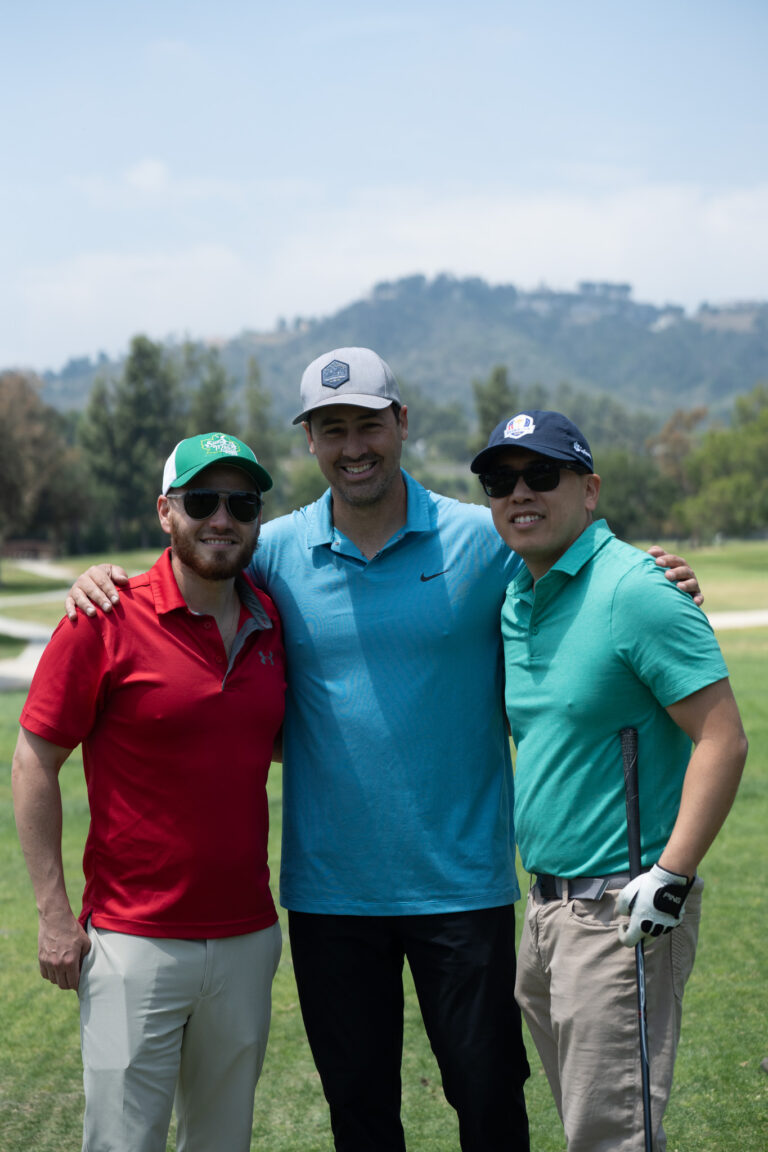 a group of three golfers all wearing different colored golf shirts