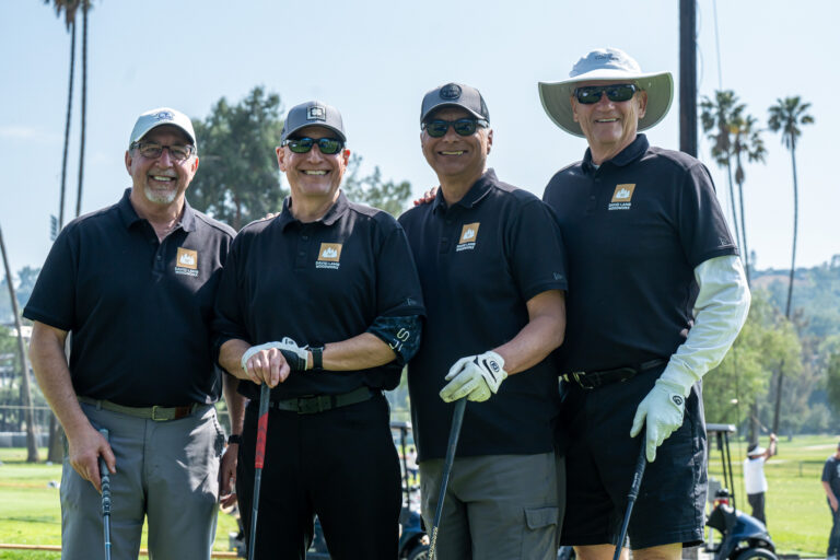 a group of four golfers all in black from David Lamb Woodworx