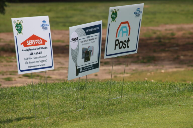 three tee signs lined up beside each other, with logos for Servpro, Longo Toyota, and Post Alarm
