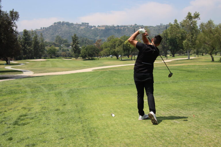 a man in all black tees off with mountains far in the distance