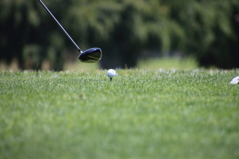 a close up of a golf club getting ready to tee off