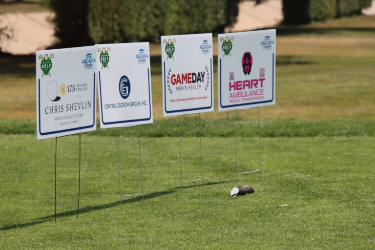 a grouping of tee signs with logos for Chicago Title, Central Escrow Group, Gameday Men's Health, and Heart Ambulance