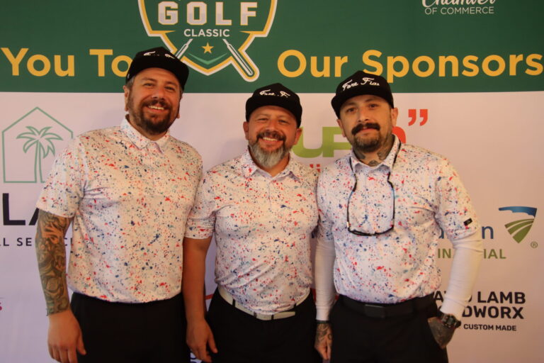 three men in matching patterned shirts standing in front of a golf backdrop