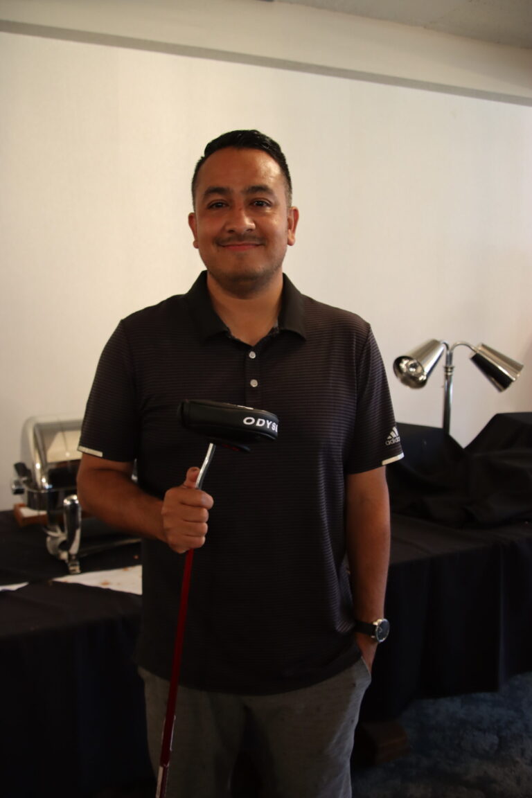 a man in a black shirt holding a golf putter