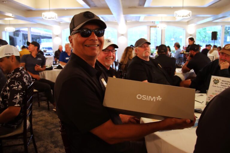 a man holding up a box with the logo from OSIM on it